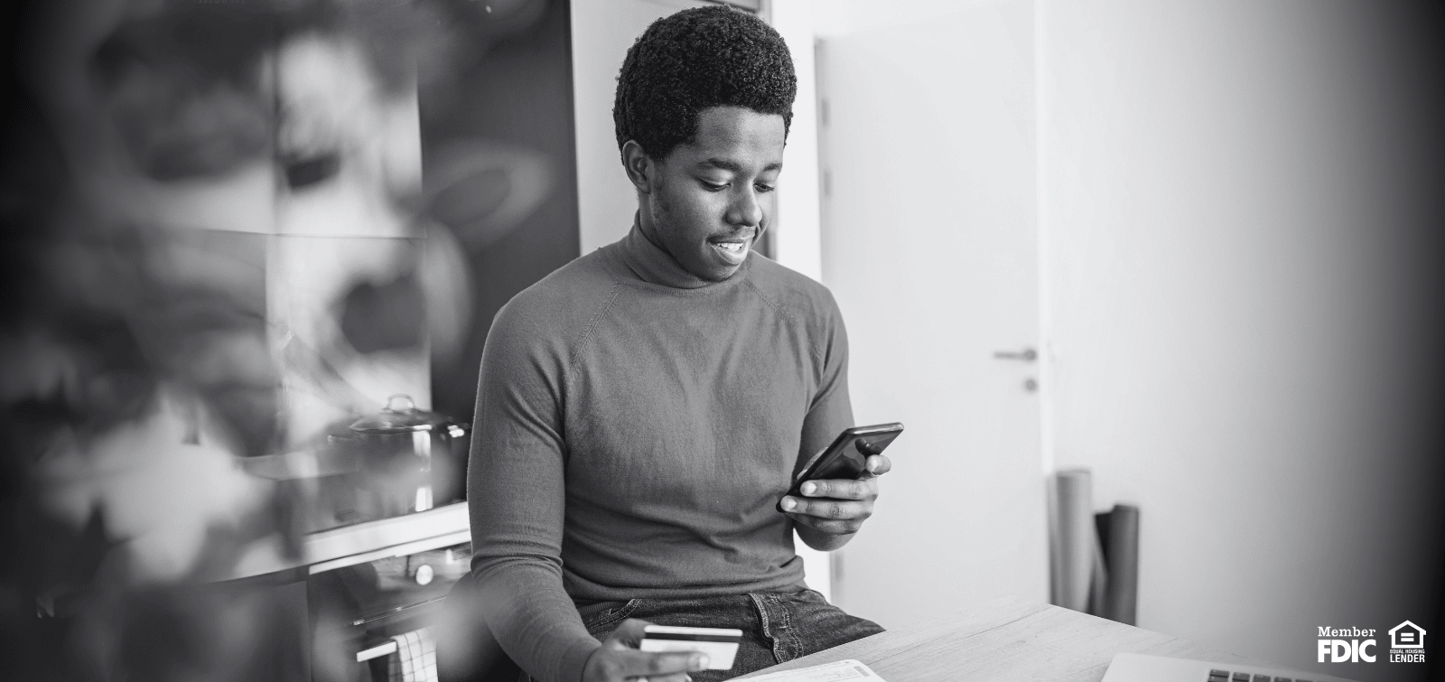Young adult looking up his credit profile, happy that he is building credit history.