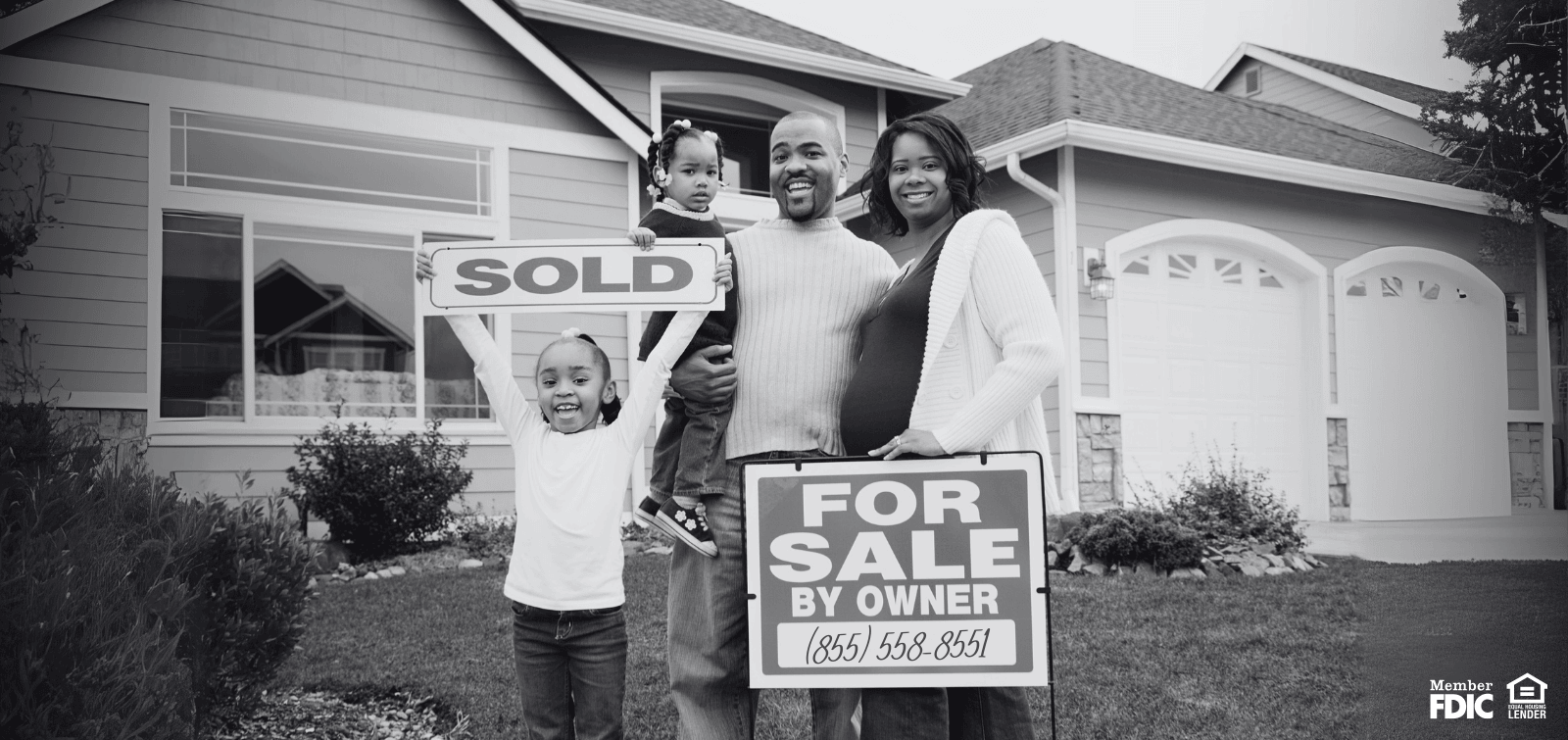 family of four with a sold sign outside their home