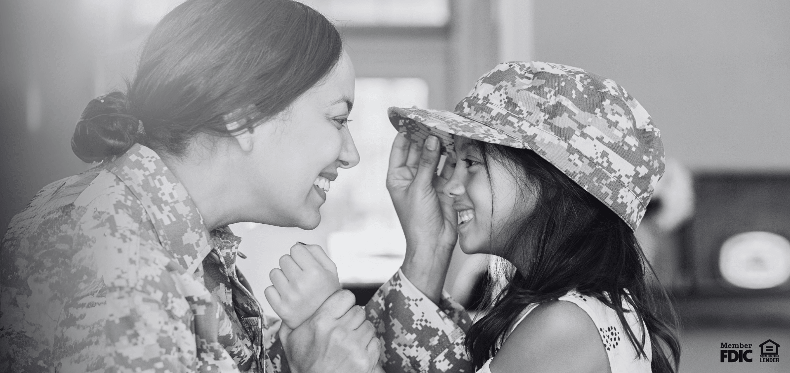 female service member placing her hat on her daughter