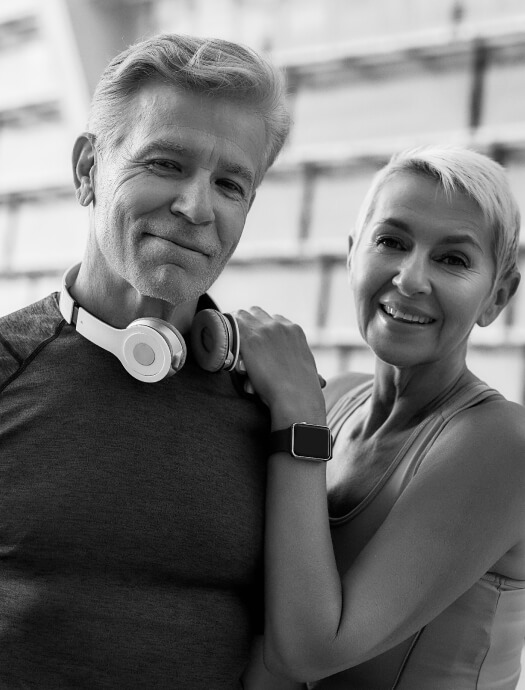 Mature man and woman smiling together in work out clothes