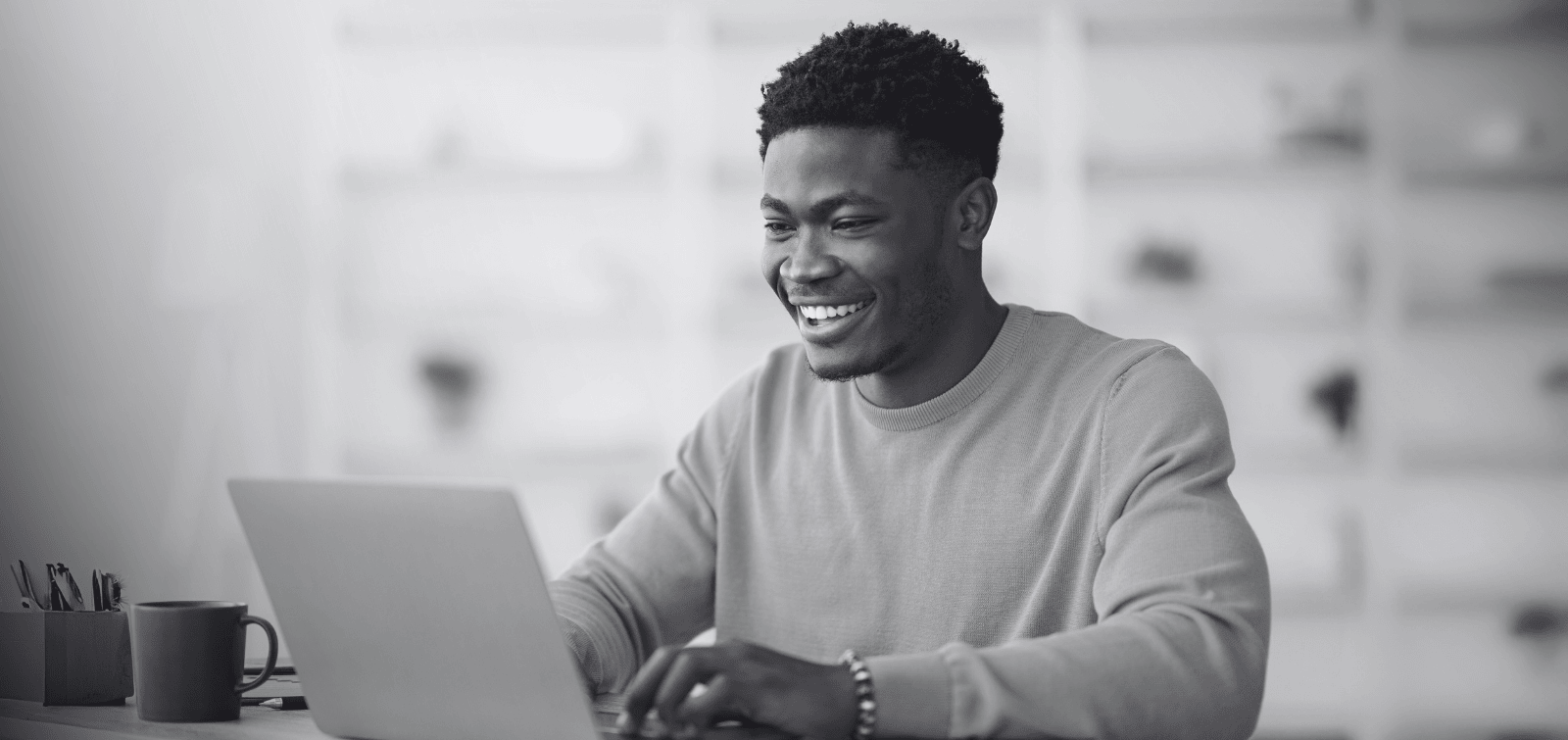 Young adult in his 20s reading about money market accounts and checking accounts on his laptop