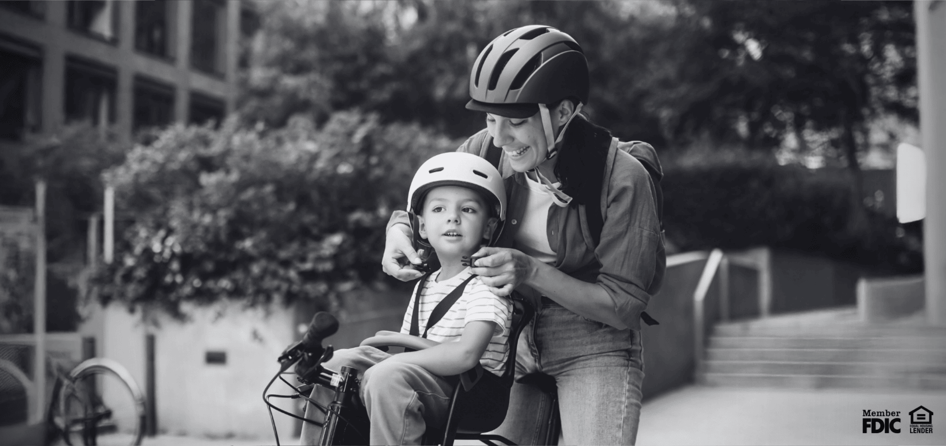 Mother and son wearing bike helmets, feeling secure in their savings and mortgage thanks to fixed interest rates.