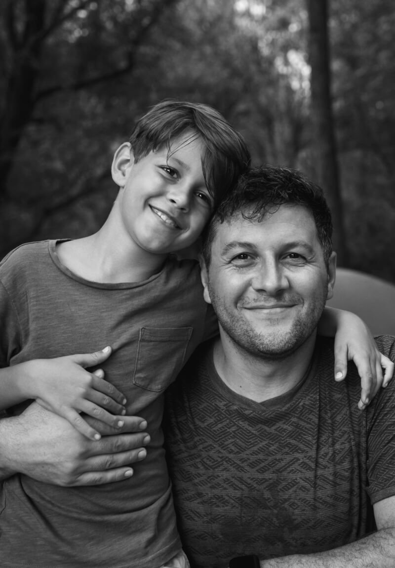 Father and son smiling together outside