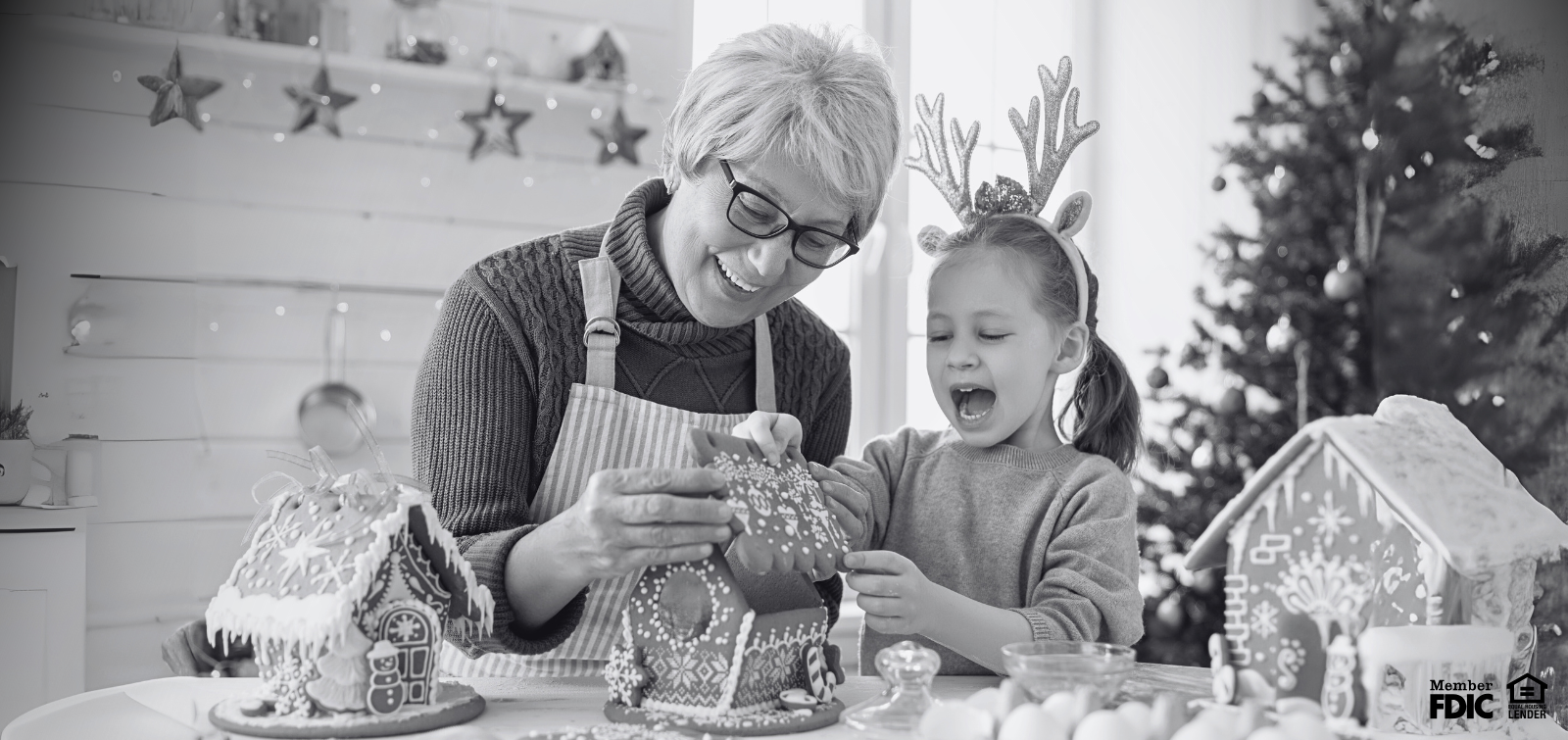 grandmother and granddaughter working on a gingerbread house