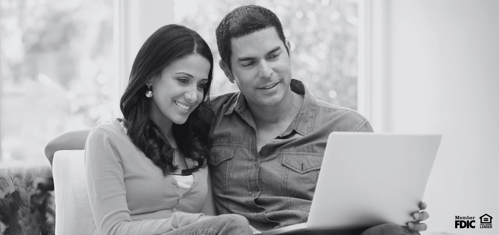 A man and woman read over their loan documents before signing.