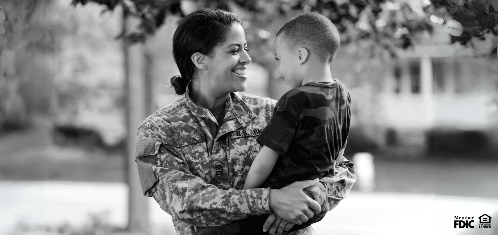 an active-duty female soldier carries a child on her hip, enjoying the benefits of free checking