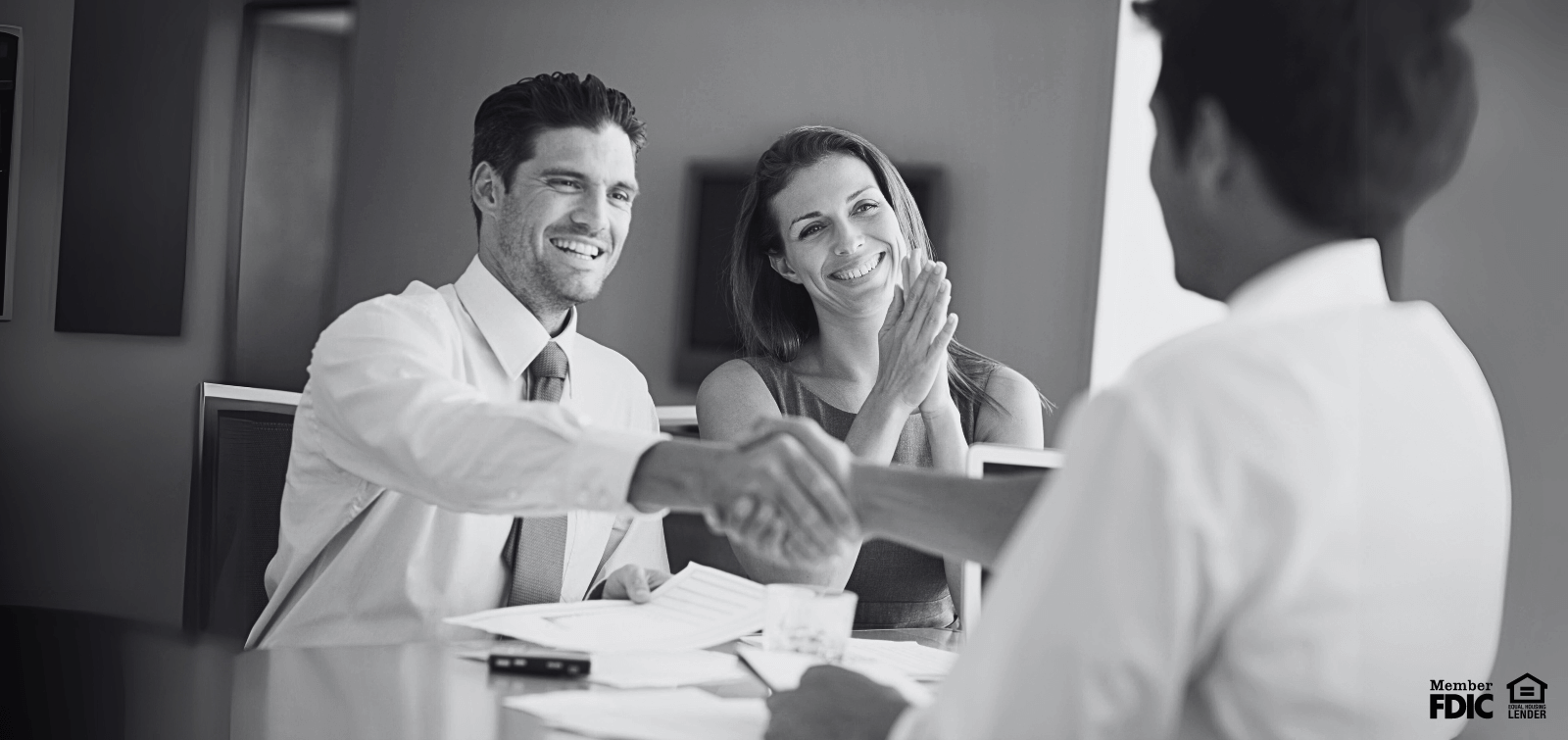 Done Deal! A business owner shakes hands with a banker after signing up for Treasury Management products.