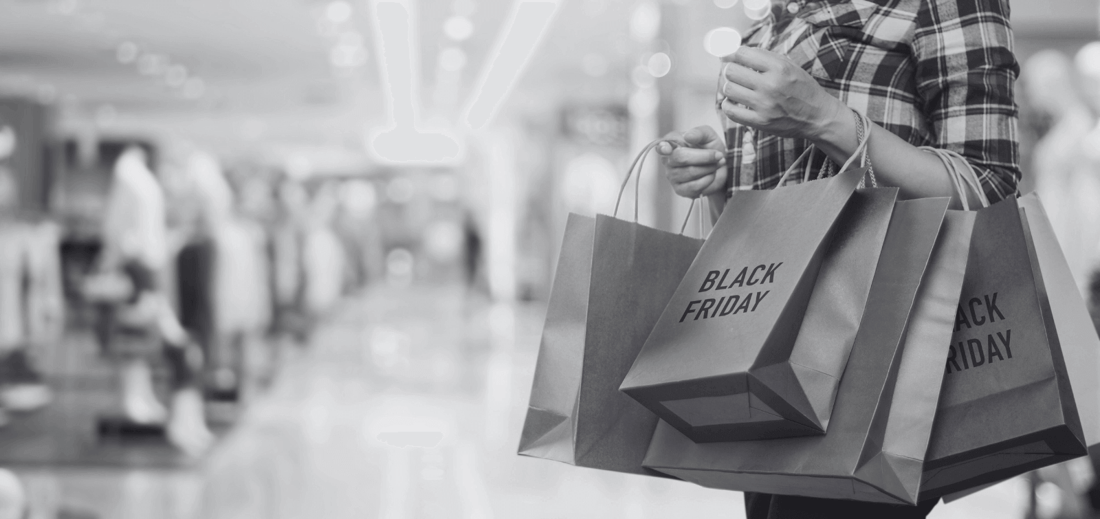 a shopper holding many Black Friday shopping bags on each arm