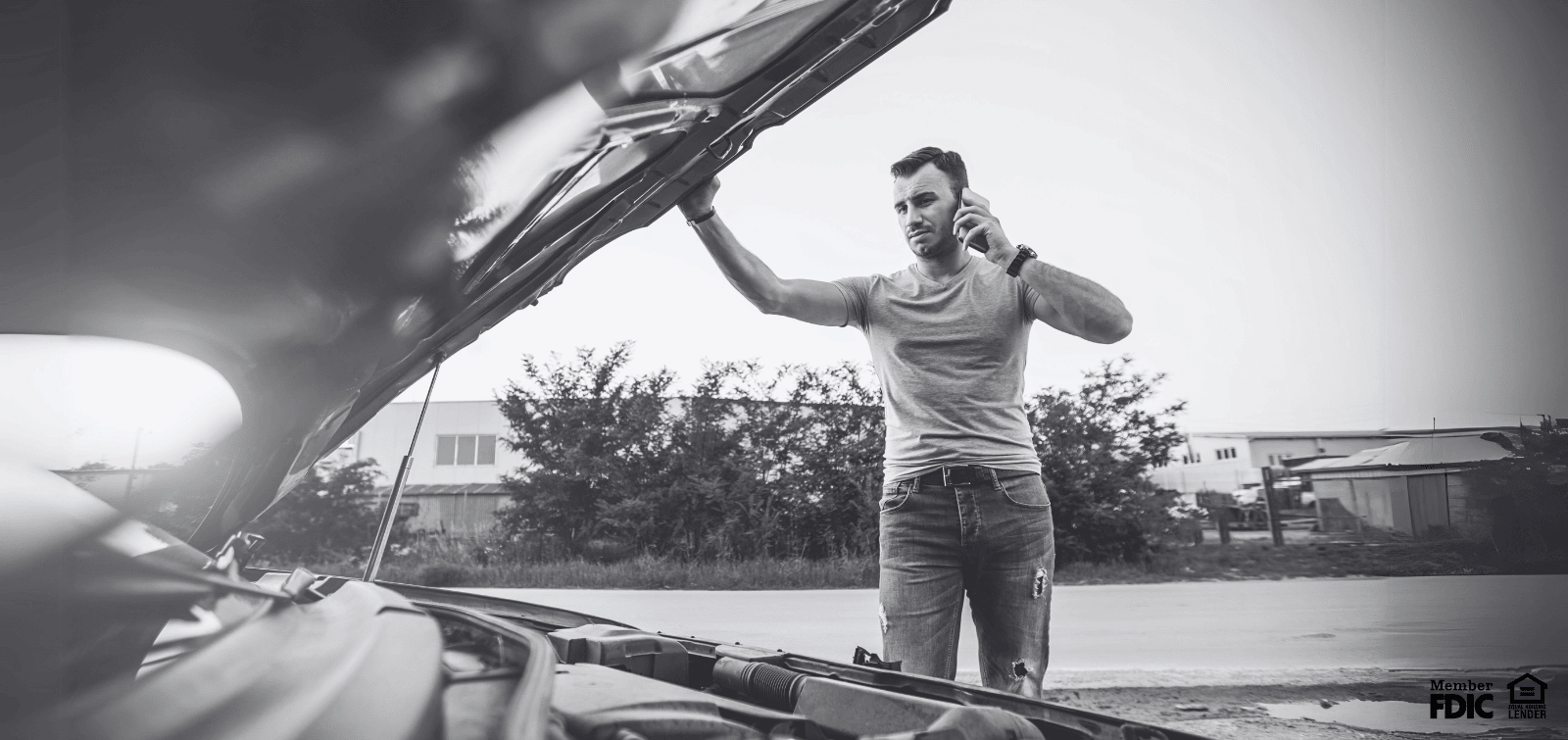 man checking under the hood of his car